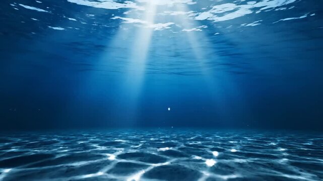 Experience the serene beauty of the deep blue ocean with mesmerizing sun rays illuminating the sandy seabed. Perfect for tranquil backgrounds.