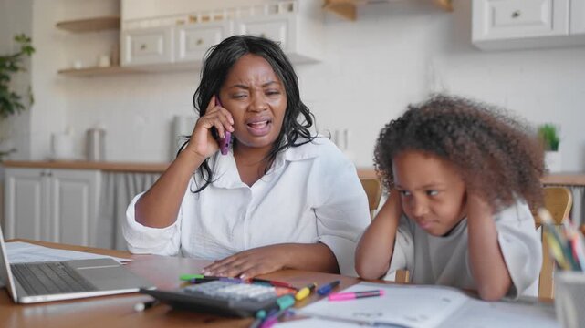 Angry african woman arguing with partners colleagues or suppliers by phone call. Little girl covering ears for not hear scream of her annoyed mother, businesswoman or housewife, emotional black lady