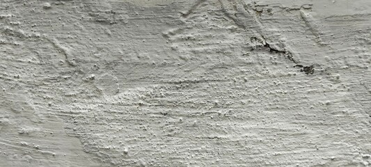 Foto close-up tekstur dinding beton kasar yang bercat putih kusam dengan retakan tipis, cocok untuk latar belakang industri atau grunge. © BAGUS