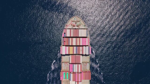 Majestic aerial top-down perspective of a large container ship cruising at high speed through the vast, deep blue ocean, carrying a full load of colorful intermodal containers