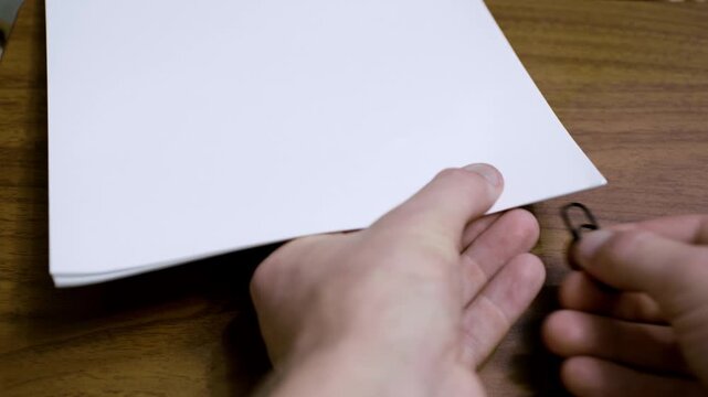 Paper clip connecting a stack of paper. A4 size paper for printer stuck together with a paper fastener