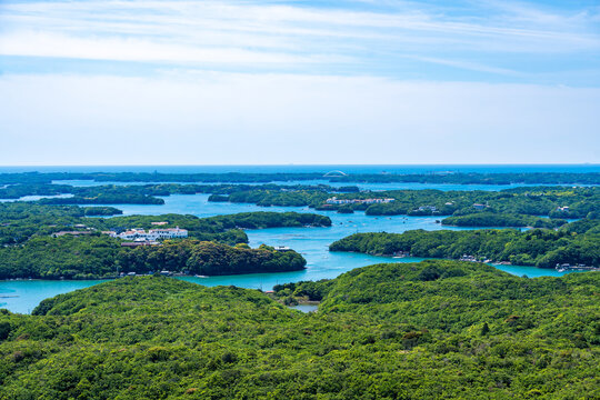 A scenic aerial perspective of the rias coast of Ago Bay from Yokoyama Observatory, featuring vibrant green islands under a bright sky. Perfect for travel marketing and natural backgrounds.