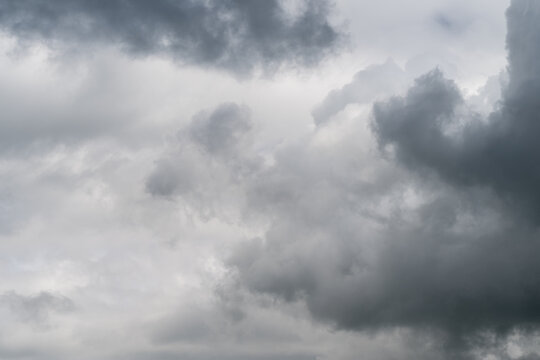 Turbulent thunderclouds with shadow pockets, dense vertical development and contrasty tones create foreboding mood, powerful visual for editorial and album art projects