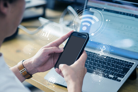 ワイヤレス通信アイコンとスマホ操作をするビジネスパーソン、デジタルネットワークイメージ　