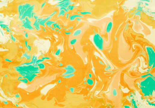 Abstract marbling background with yellow, orange and green paint swirls.