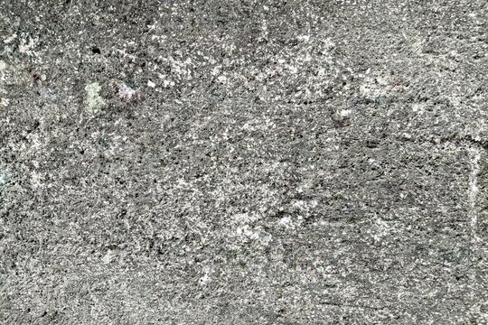 Rough concrete wall texture background with weathered and pitted surface