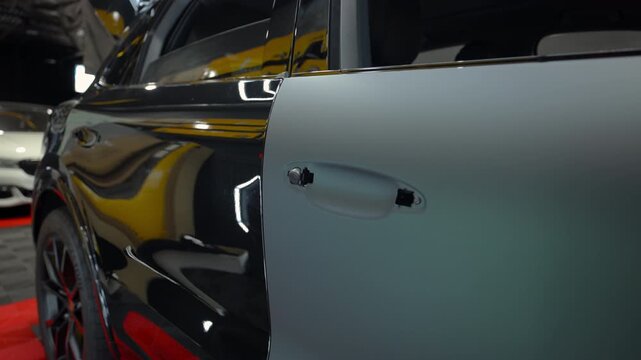 Close up shoot of a car installed protective vinyl film inside automotive detailing studio during luxury car customization and paint protection service