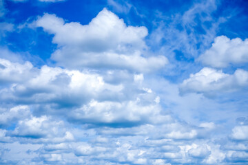 Obraz premium Layered white cumulus clouds fill deep blue sky, concept of weather background, airy texture and natural design space.