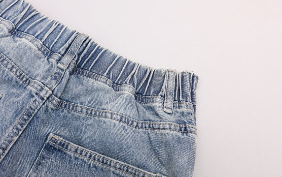 Loose fit light blue women's jeans with elastic waistband, light blue background