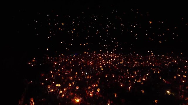Crowd release sky lantern in dark night with magical glow for culture celebration and holiday festival background
