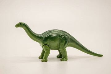 Green Dinosaur Toy Standing on White Background © Angel