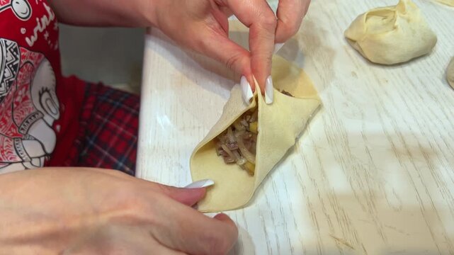 Close-up of woman hands making festive manti dumplings for Eid