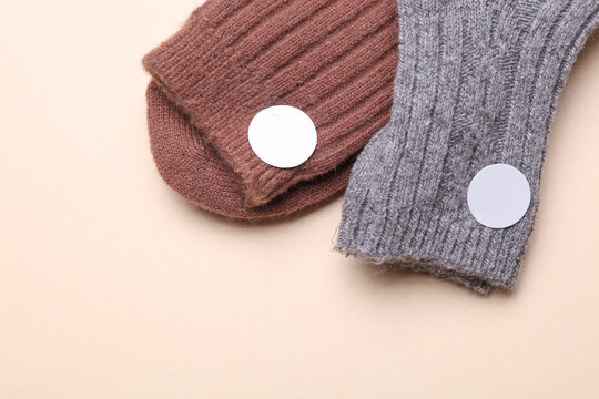 Socks with white blank stickers on a beige background