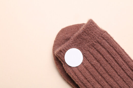 Sock with white blank stickers on a beige background