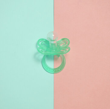 Baby pacifier on a blue pink background