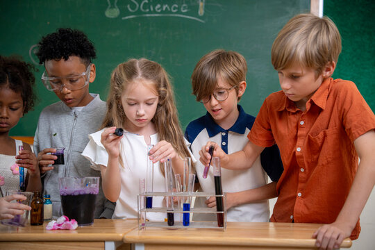 Diversity children doing a chemical experiment in laboratory at school. Kids at elementary school learning science chemistry. Fun study back to school. Education and research.