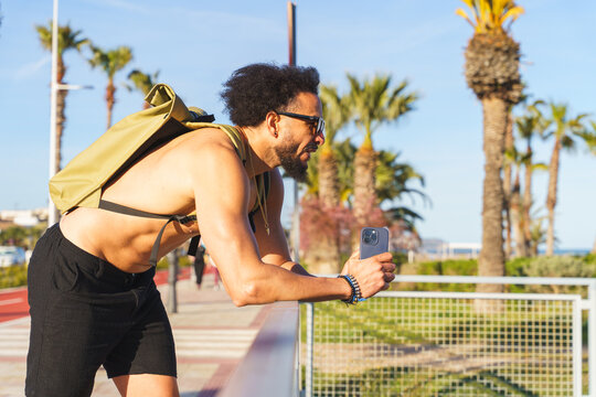 Latino man in rollerblades pausing for a video on a sunny seaside promenade