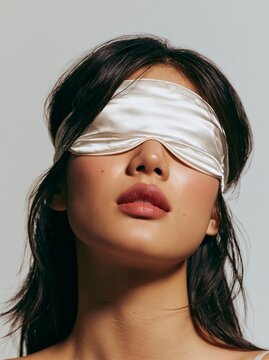Young East Asian woman wearing a sleep mask with a gentle smile
