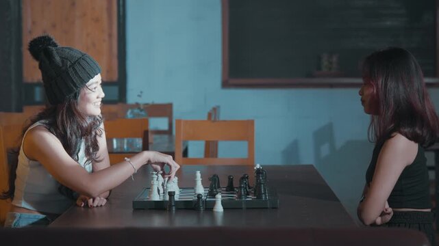Two Young Women Playing Chess in a Cafe Setting