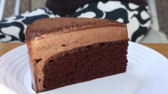 Close up of a fork scooping a delicious bite of rich velvety chocolate mousse cake