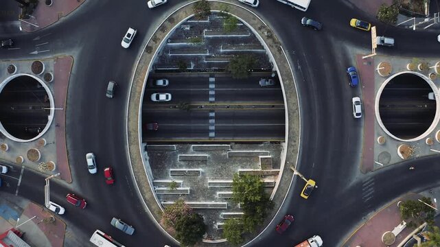 City traffic flows around a roundabout from an aerial perspective during daytime video cars vehicles view transportation road