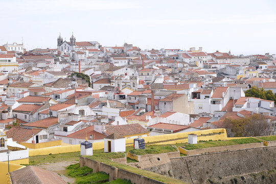 Panoramic high-angle view of the historic white houses and terracotta roofs in the garrison border town of Elvas, looking over the medieval fortification walls and bastions, Alentejo region, Portugal.