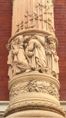 Naklejka premium Ornate Terracotta Column Detail with Intricate Figurative and Floral Carvings