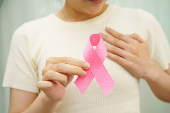 Asian woman with pink ribbon for October world breast cancer day.