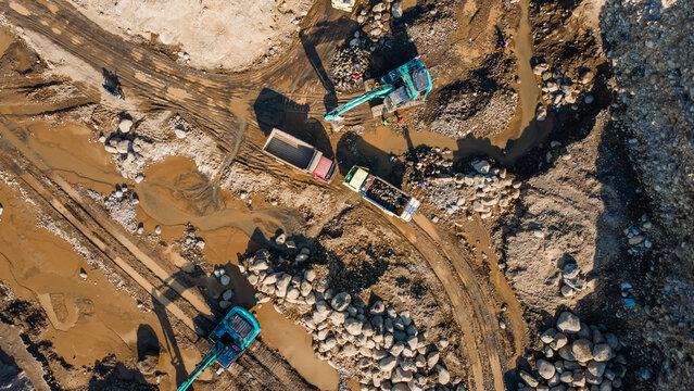 Aerial View of Excavator and Dump Truck Working in Rock and Ore Quarry Mine, Construction and mining site view from above.