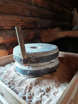 Close-up of authentic millstones with ground flour and wheat grain, traditional craft and heritage.