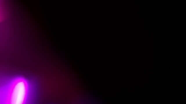 Real intense violet-pink holographic light glows brilliantly from the upper corner, prismatic shimmer over the dark background. Organic optical magenta sweep for nightclub visuals and DJ event content