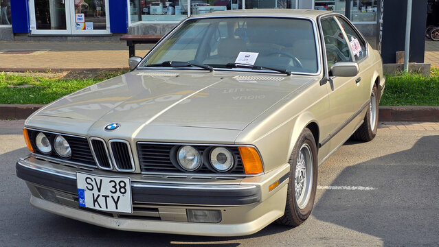 Piatra Neamt, Romania - June 7, 2025: Detailed shot of a gold 1987 BMW 635 CSi. This timeless German luxury coupe showcases its classic design, distinctive grille, and polished features.