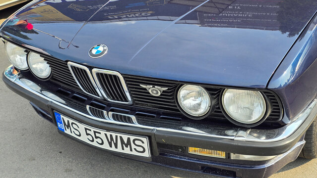 Piatra Neamt, Romania - June 7, 2025: Close-up of a classic dark blue 1987 BMW 528i (E28). Features iconic kidney grille, dual headlights, chrome details, and vintage front end design.