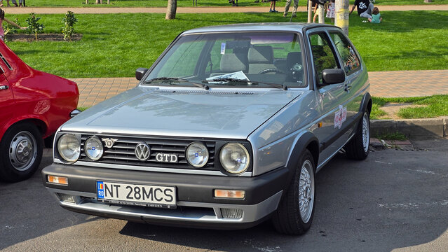 Piatra Neamt, Romania - June 7, 2025: A three-quarter front view of a silver Volkswagen Golf Mk2 GTD with a Romanian license plate, parked next to a red car at an outdoor event.