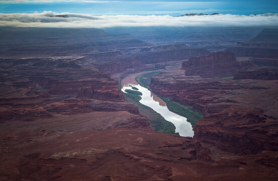 Dramatic aerial view of river winding through vast red canyon