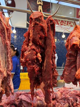 Fresh raw beef hanging at a traditional local wet market stall. Beef Brisket.	