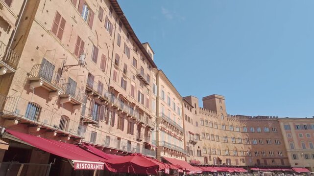 Shot of Siena&rsquo;s Piazza del Campo showing the curved medieval fa&ccedil;ades, with just a touch of the red tendas at the bottom framing the square&rsquo;s shape.
