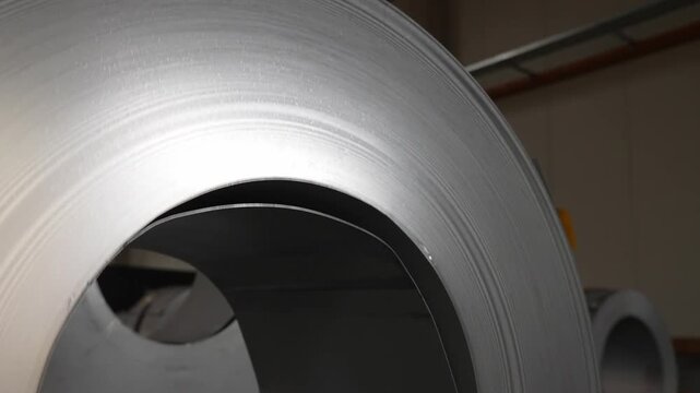 Steel coil close-up showcasing the metallic texture and coiled structure of raw steel for industrial processing and metal fabrication.