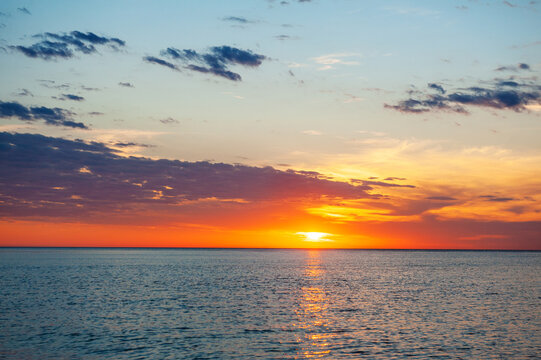 Beautiful sundown background with sea and cloudy blue sky