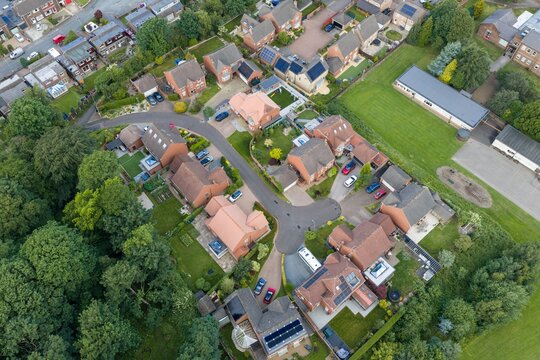 Aerial view of detached family homes beside Silcoates School in Wakefield West Yorkshire showing a residential cul de sac private gardens mature trees and recreational grounds from above
