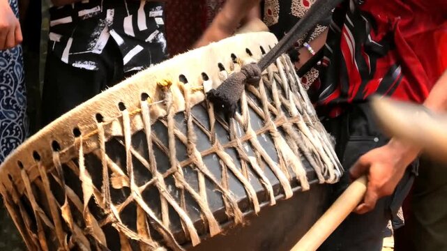 Closeup of a drummer performing with Thambolam, a large percussion drum used in festivals and celebrations in India