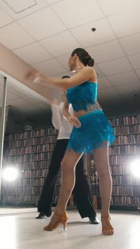 Young beautiful man and woman dancing and rehearsing Latin American dance in costumes in the Studio
