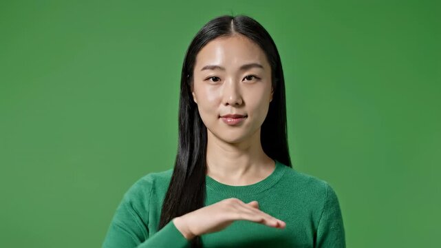 Young woman gesturing hello and thank you with a smile in a studio setting