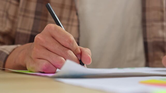 Close up of graphic designer hand drawing creative sketch with pen on paper in minimalist workspace