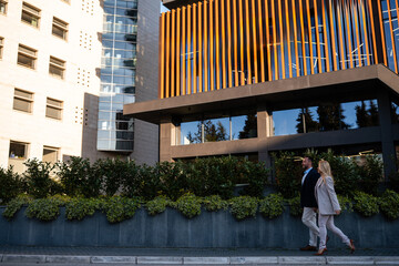 Business people walking past modern corporate building © Zoran Jesic
