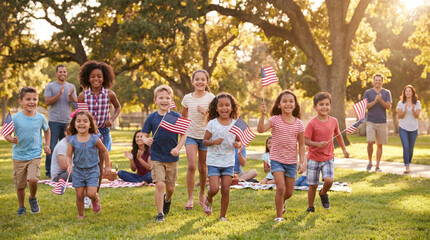 Fototapeta premium Children run with American flags during a summer celebration in a park filled with trees. Independence day. Independence day