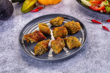 Fototapeta premium Fried chicken nuggets on grey plate with vegetables