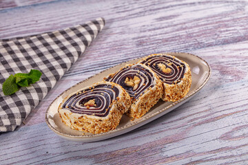 Sliced poppy seed roll with nuts on ceramic plate © Andrei Starostin