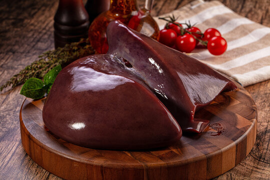Raw beef liver on wooden board