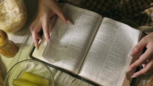 young conservative asian Woman Reading the Bible at table with bread food and drink indoors